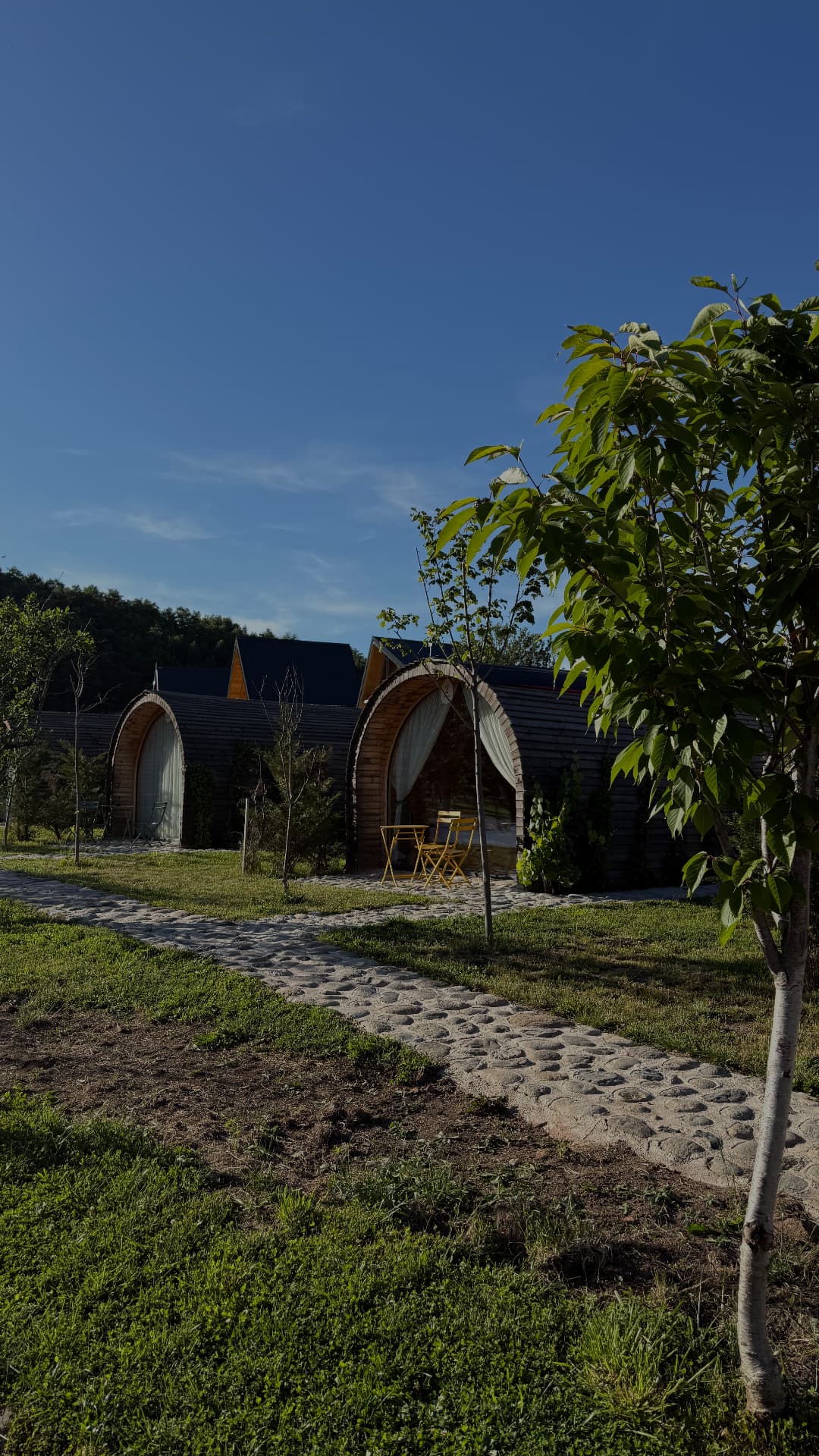 Wooden arch bubble villas standing in a green meadow in the hills of Kosovo